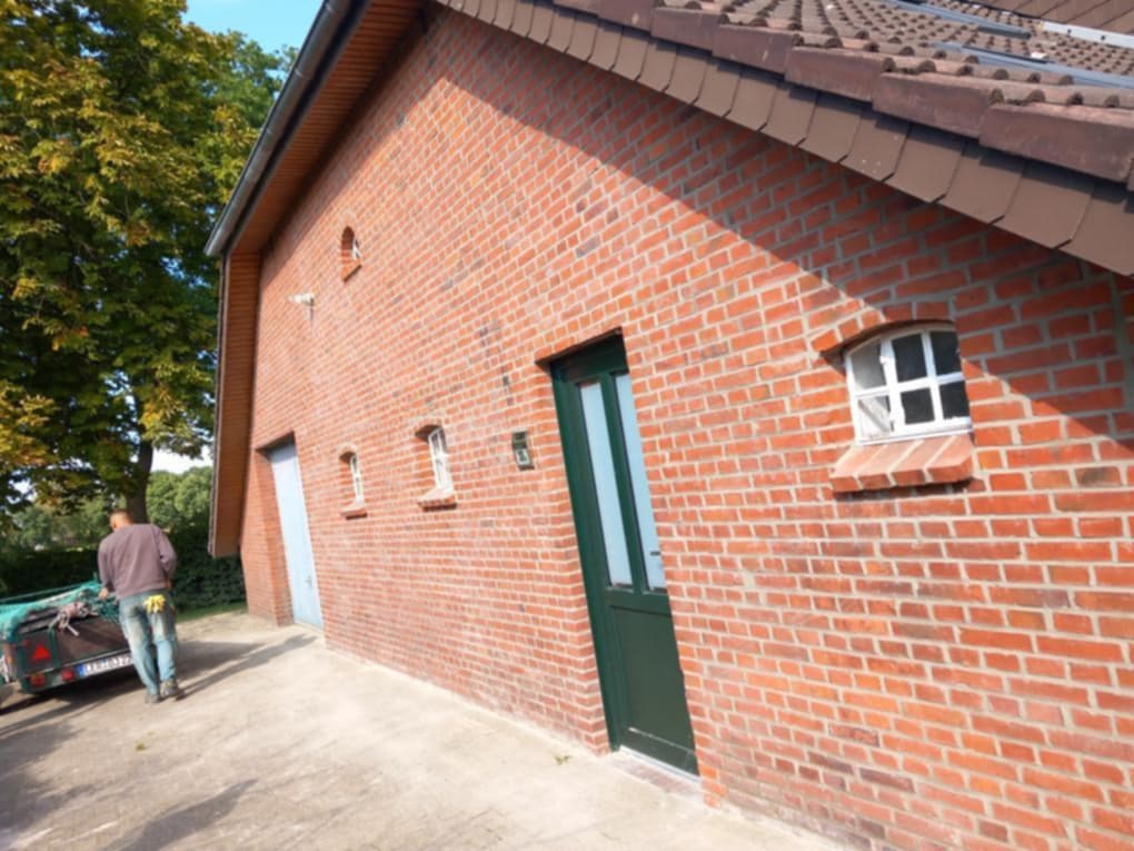 Seitenansicht eines Wohnhauses mit gleichmäßig verfugter Klinkerfassade